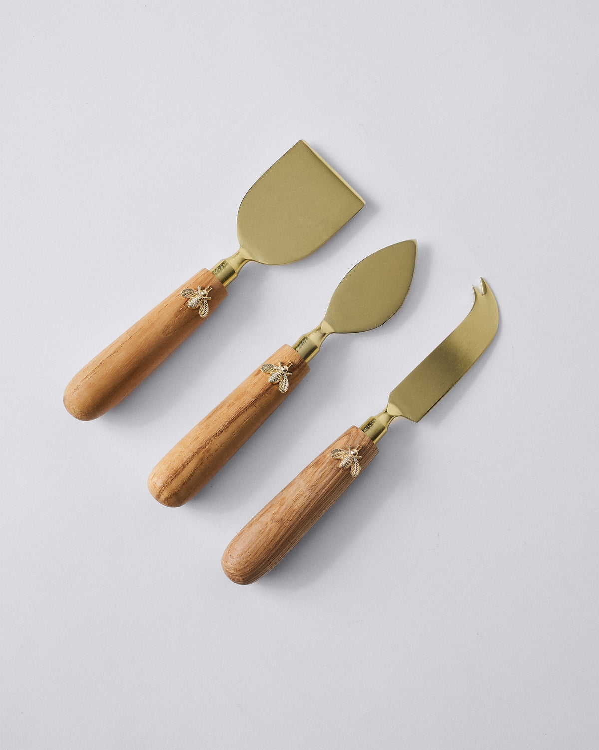 Three Garo cheese knives laid flat showing cleaver, spade, and forked blades.