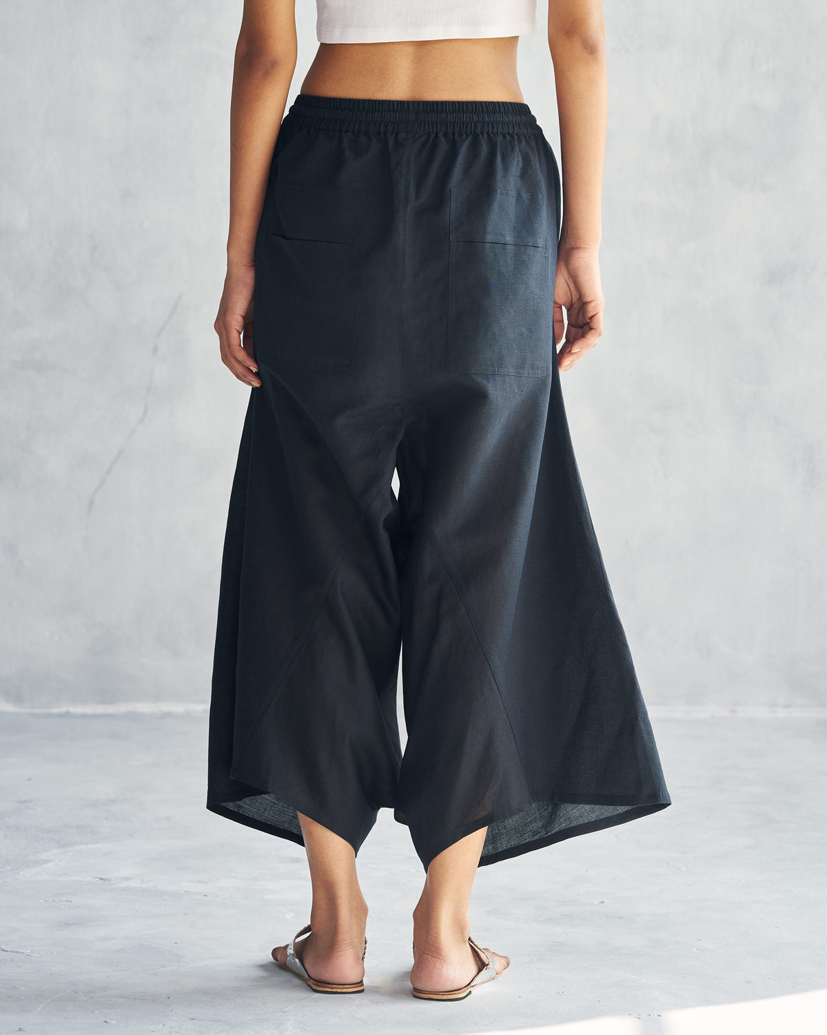 Back of black Yoka trousers worn by a person.