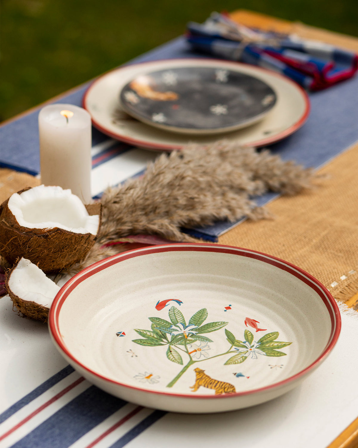 Nadi pasta bowl with tiger and plant print set on an outdoor dining table.
