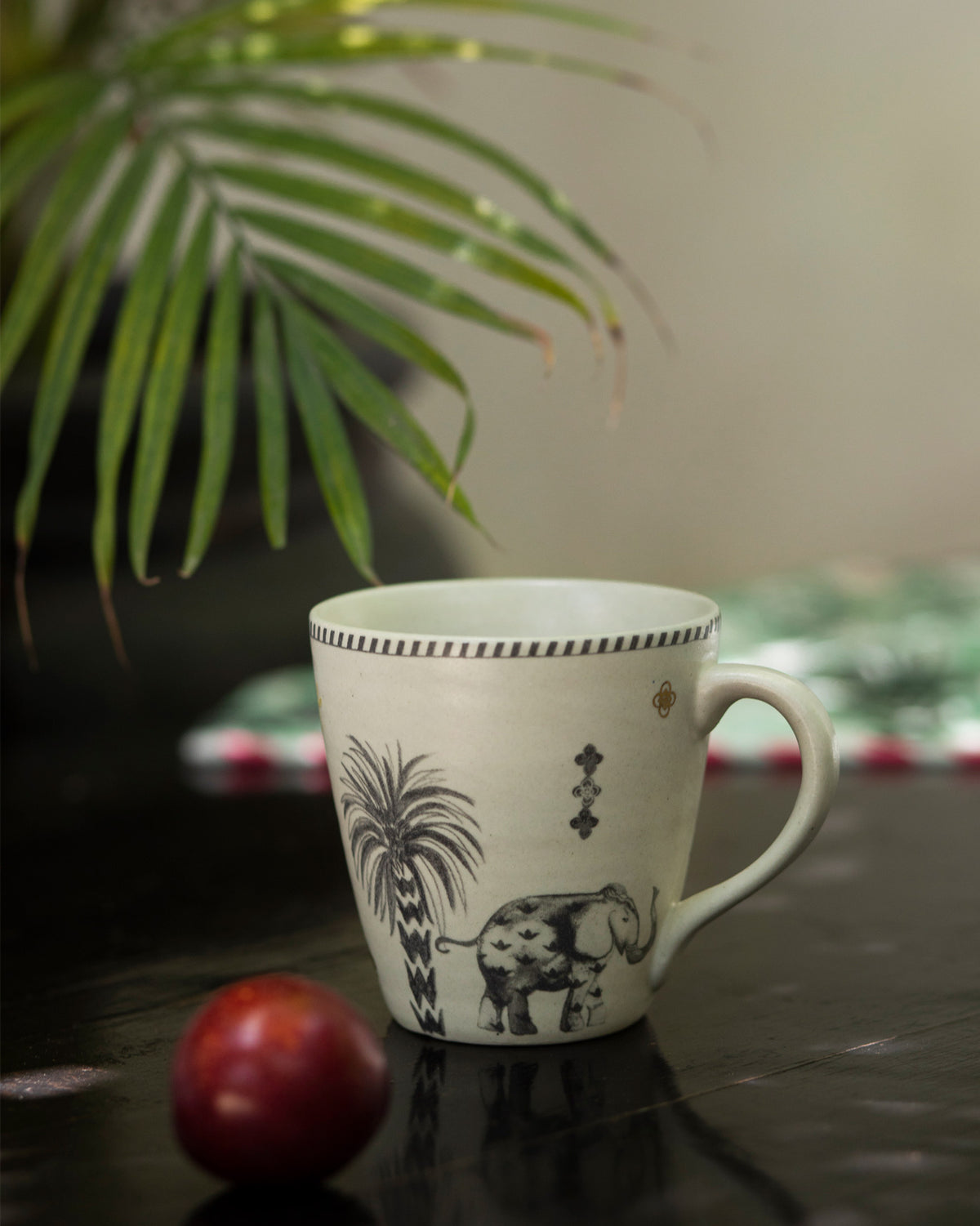 Periyar Mug Ivory with an elephant and palm tree motif.