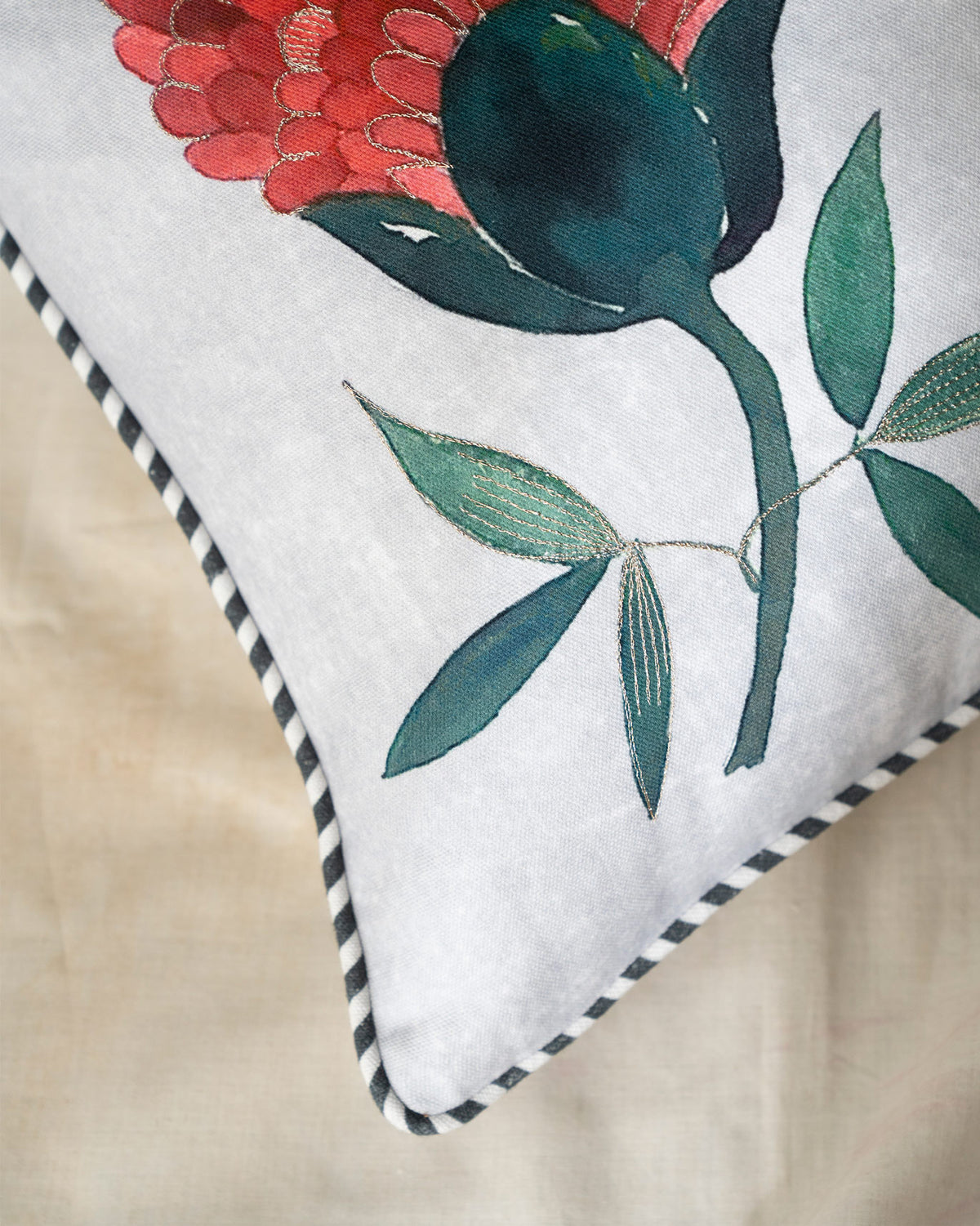 Close-up of the Peony Cushion Cover showing a red bloom, teal bud and stitched leaves.
