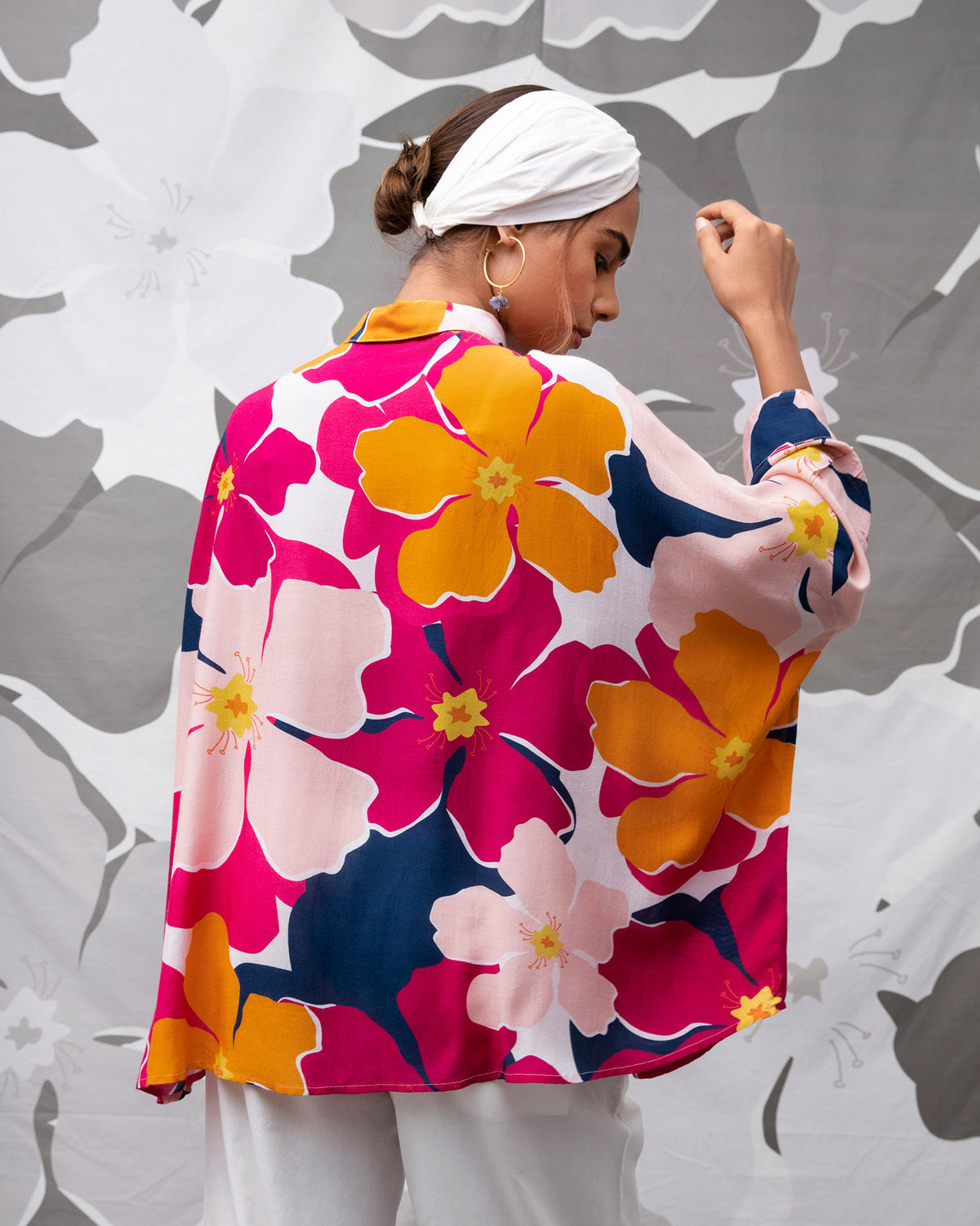 Back of the Boxy Shirt in a pink and orange floral print worn by a person.