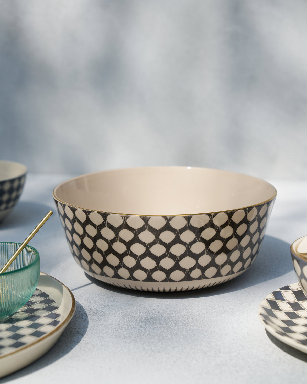 Fez curry bowl with charcoal pattern styled among matching plates.