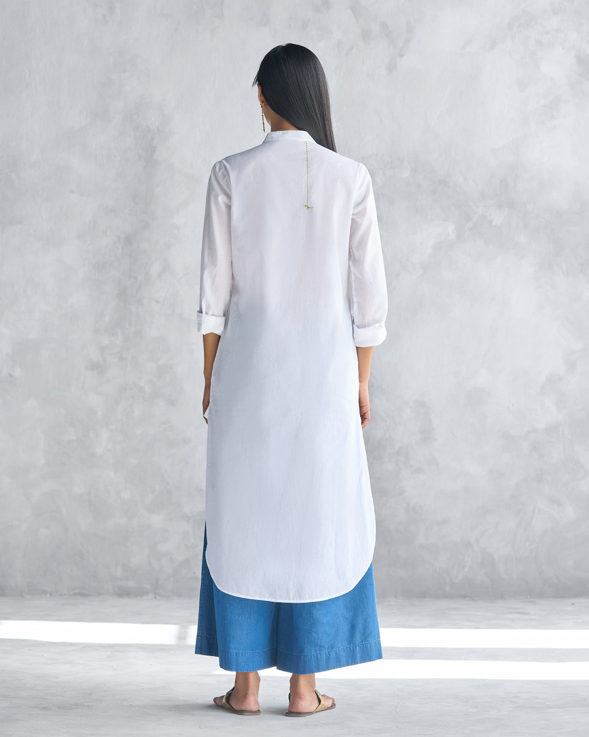 Back of a white long kurta showing the curved mid-calf hem.