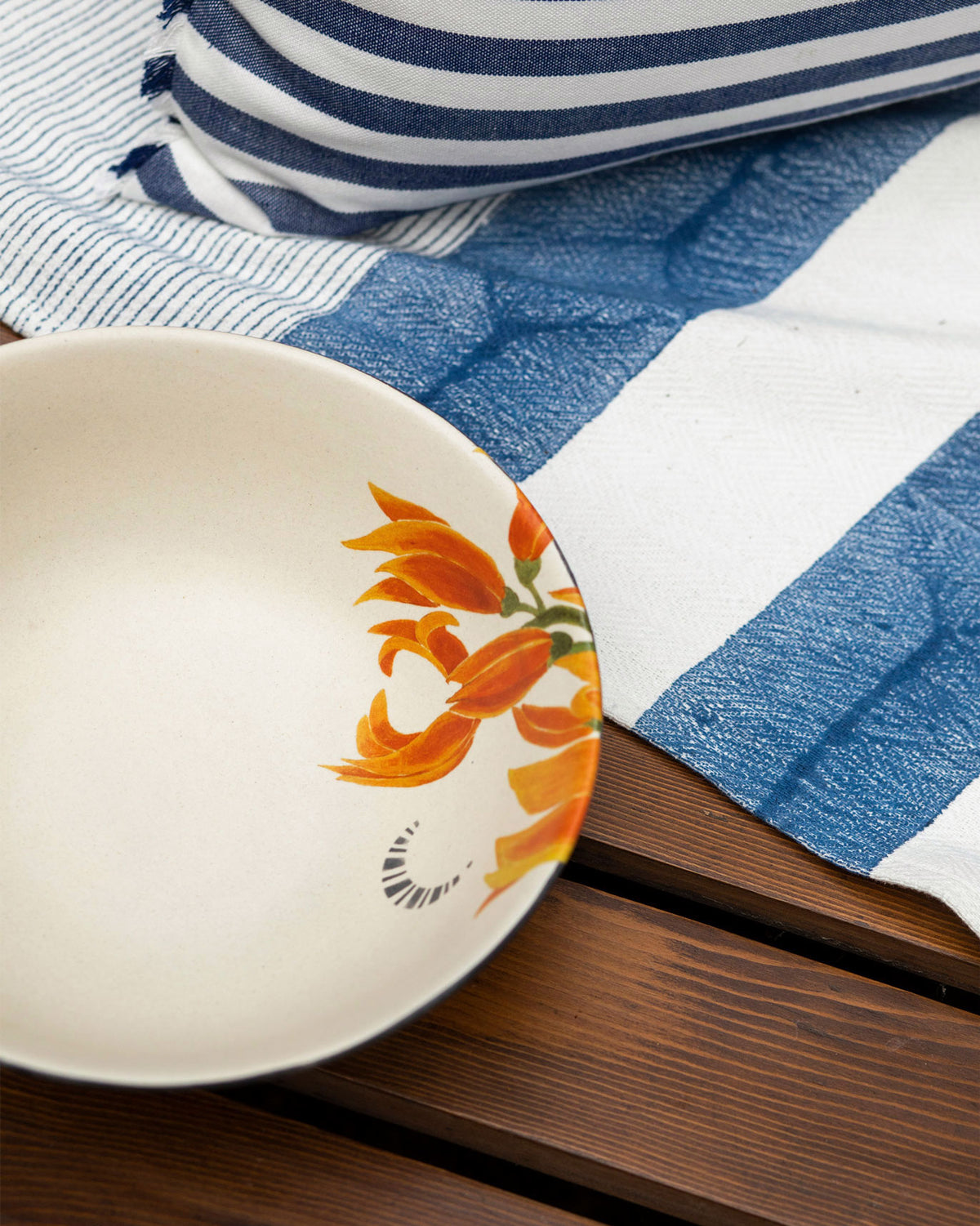 Close-up of orange flower print inside a cream Nadi curry bowl.