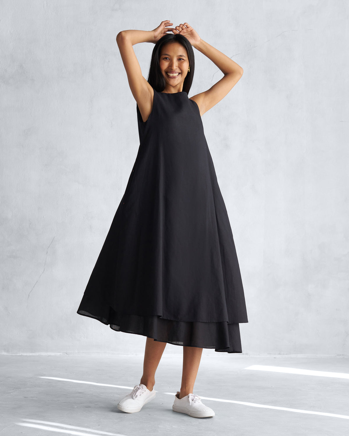 Person wearing a black Double layer dress with a flared A-line hem.