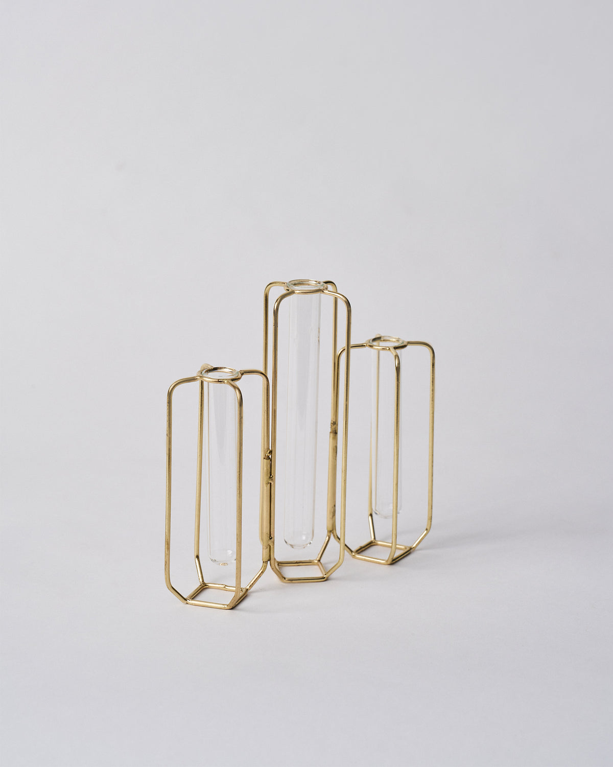 Angled view of three gold wire test tube vases of different heights.