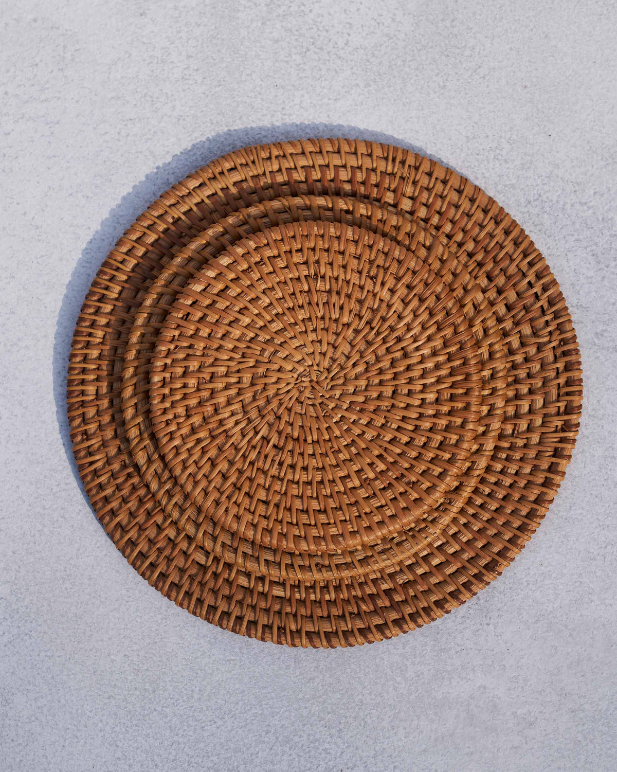 Close-up of a Rattan Trivet showing its spiral woven pattern.