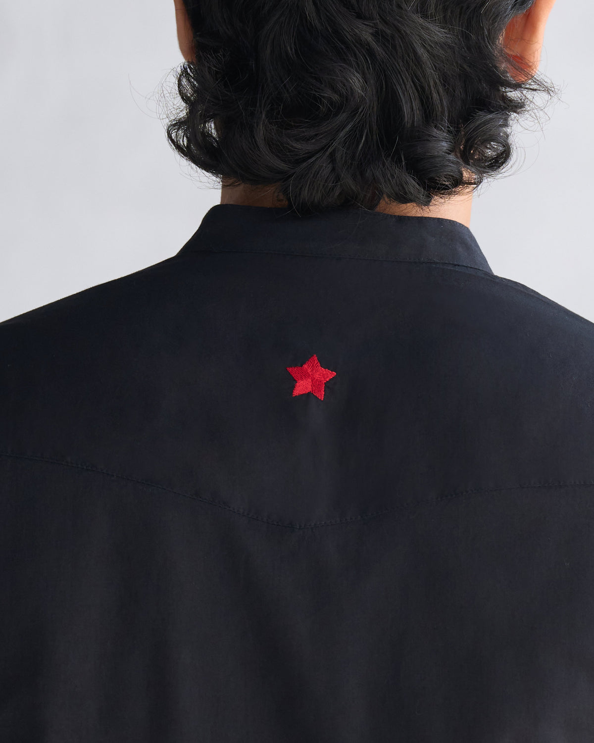 Close-up of a black Pondicherry kurta back with a small red star.