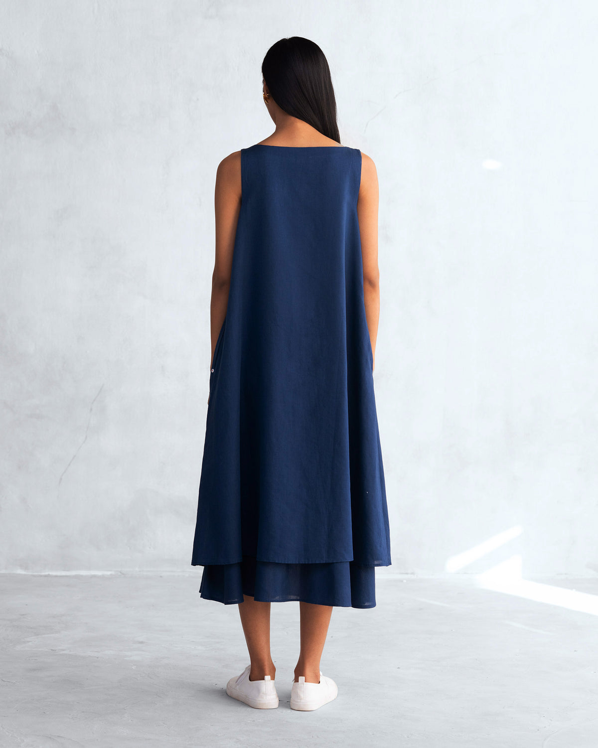 Back of a navy Double layer dress worn by a person.