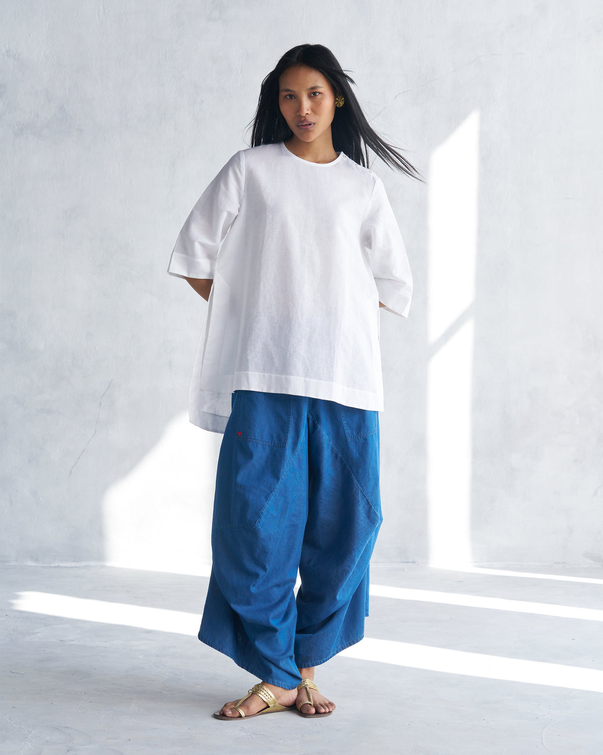 Person wearing a white High Slit Top with a relaxed mid-thigh length.