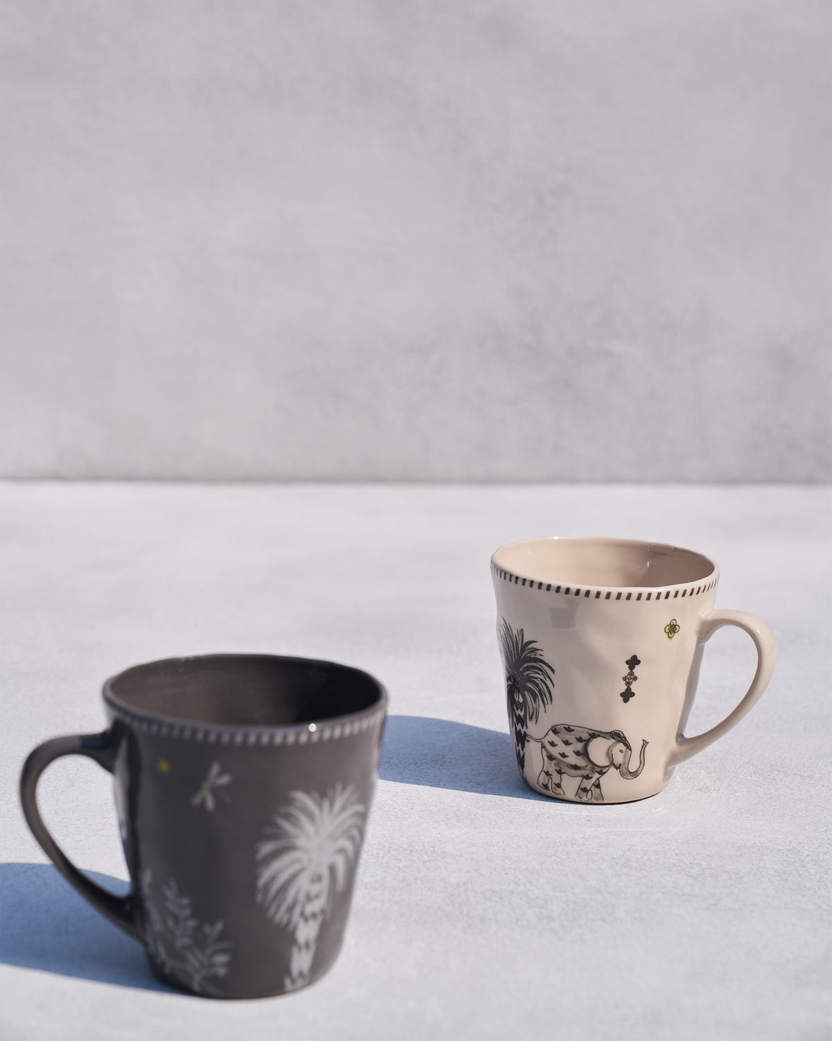 Pair of Malabar conical mugs with palm, elephant, and tiger coastal motifs.