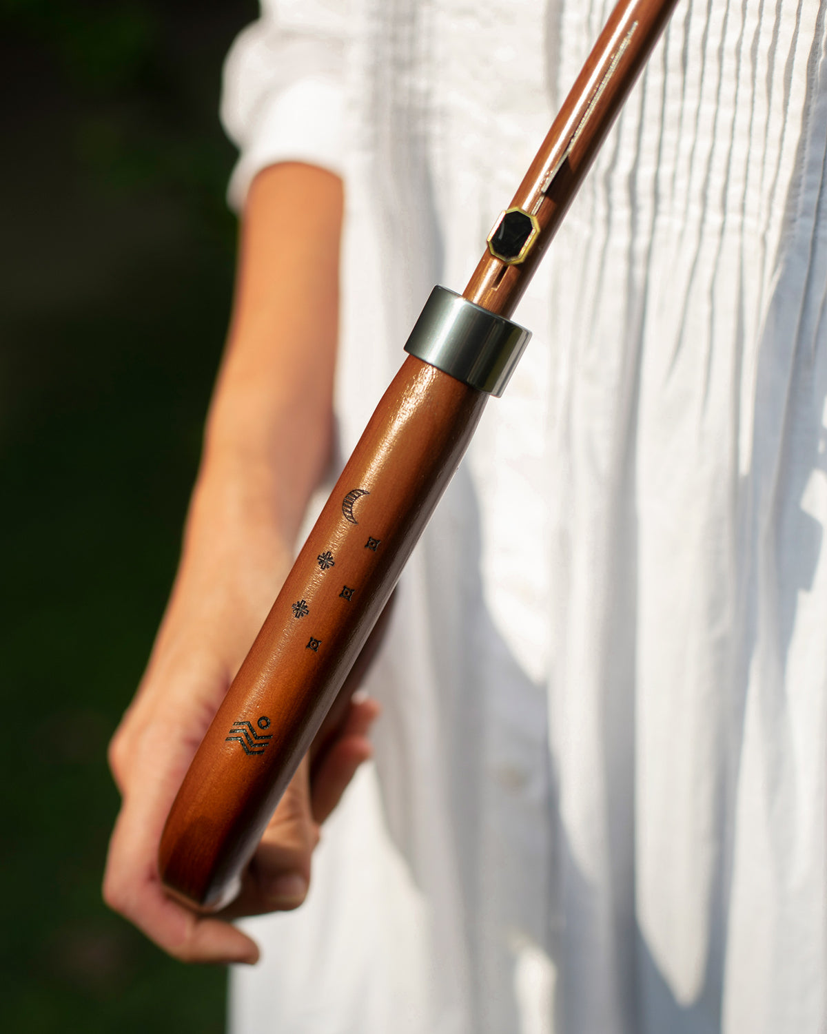 Close-up of the Periyar Umbrella wooden handle with etched moon and wave motifs.