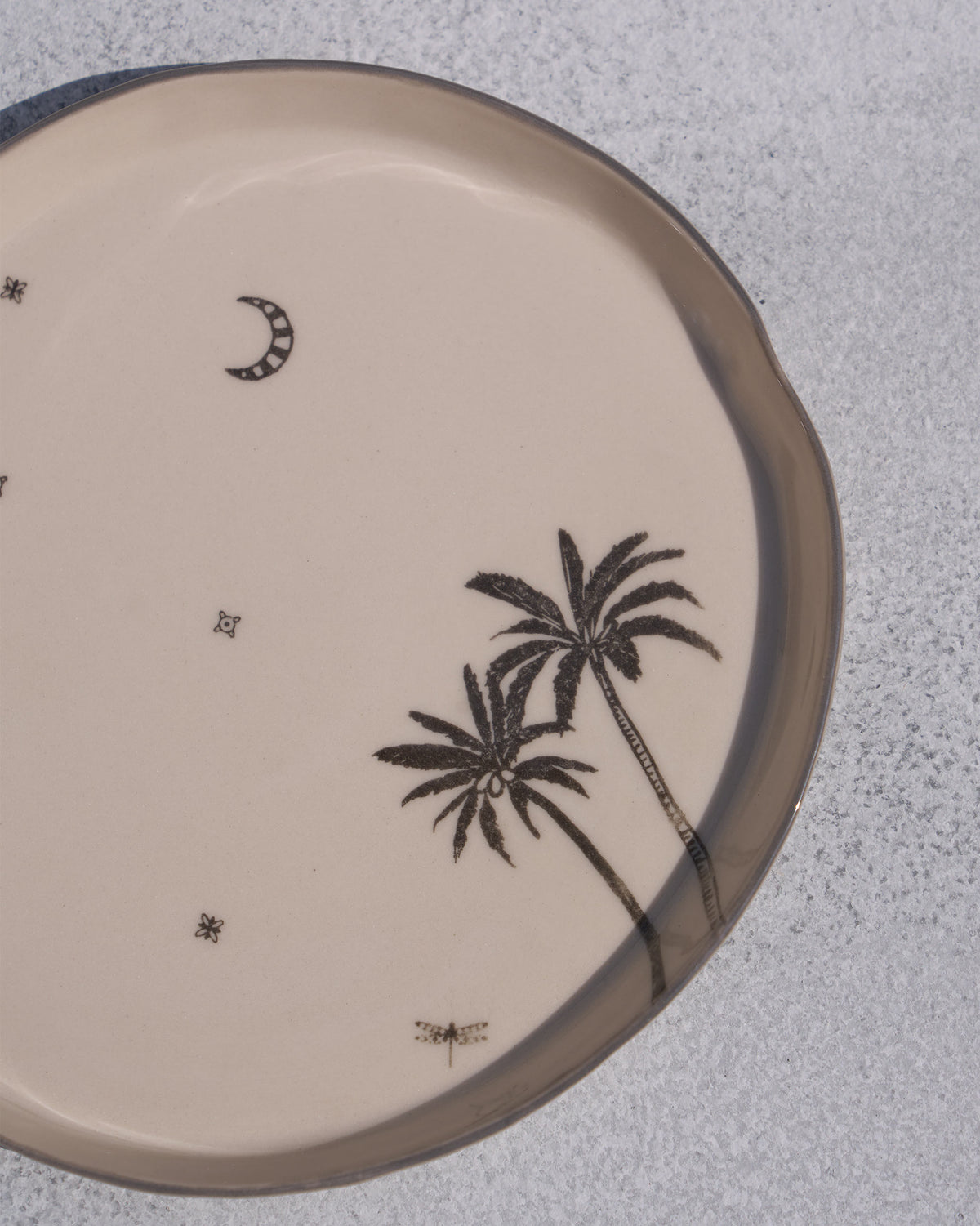 Close-up of the Swaying Palm Desert plate showing palm trees and a crescent moon.