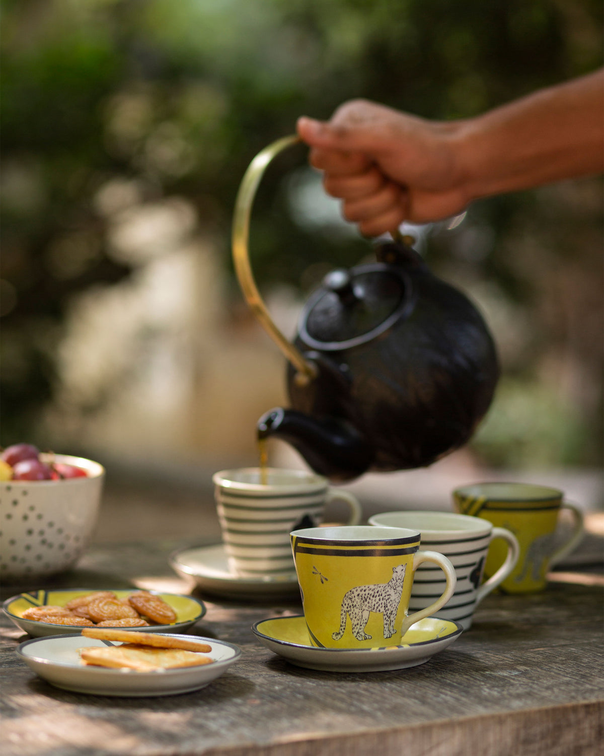 Chand Espresso Mug with a yellow leopard design, set among striped mugs.
