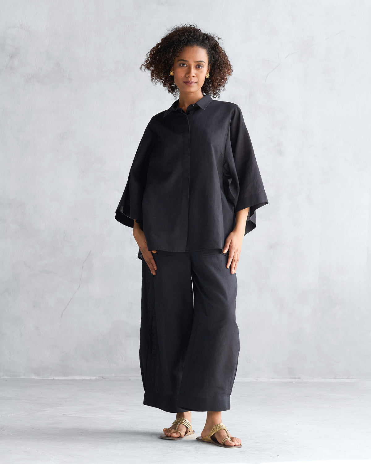 Full-length view of a black Drop armhole shirt worn by a person.