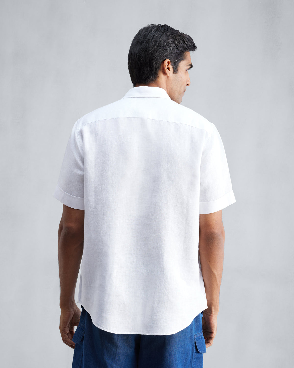 Back of a white half-sleeve shirt worn by a person.