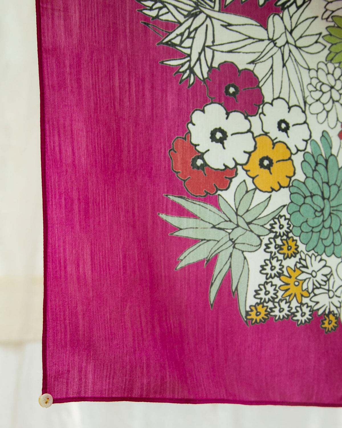Close-up of the Cascade Scarf's magenta edge with white, yellow and green flowers.