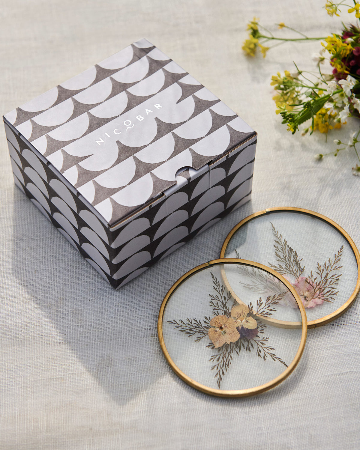 Waadi Coasters beside their grey patterned box.