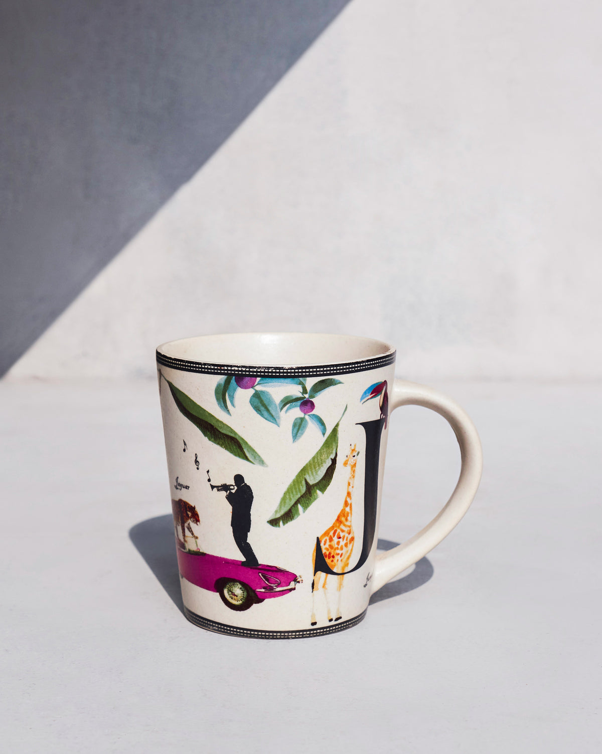 Side view of Jungle mug showing a pink car and a giraffe.