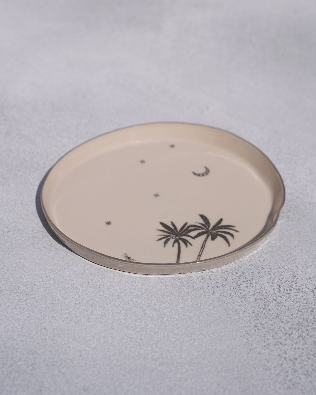 Angled view of the Swaying Palm Desert plate with palm trees and stars.