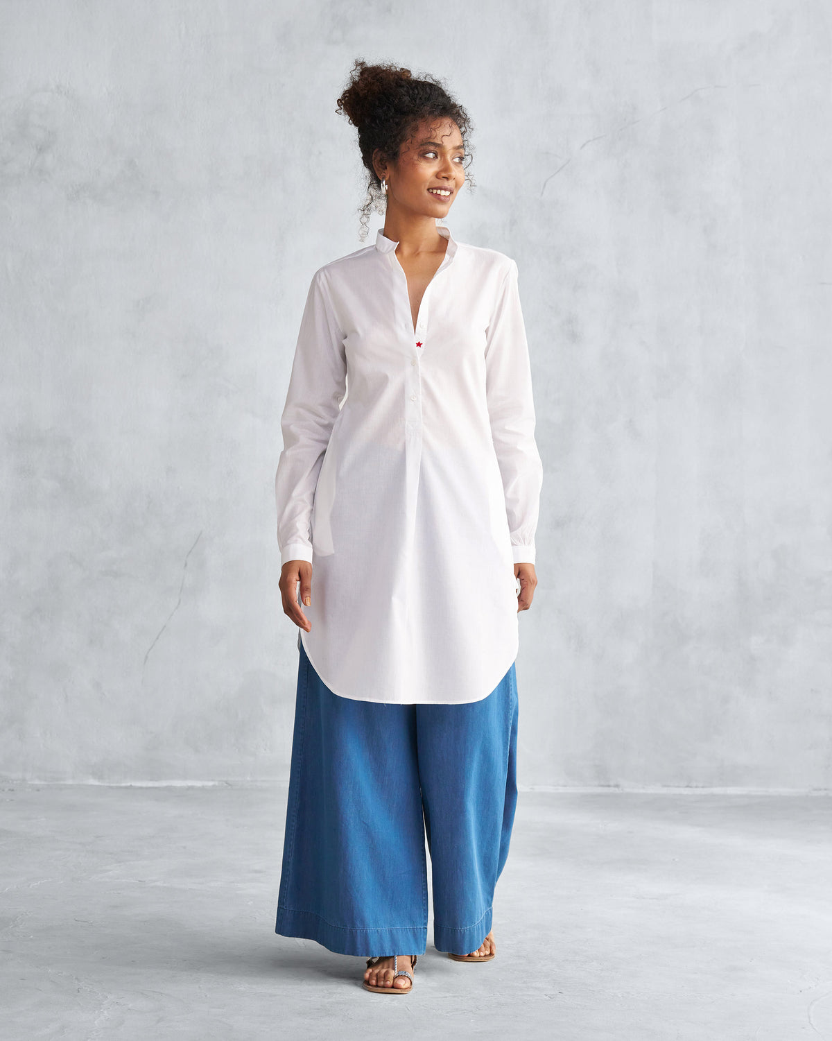 Person wearing a white mid-length kurta with a curved hem.