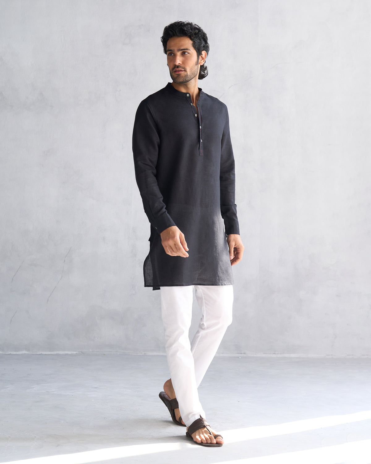 Person wearing a black Chandni Chowk kurta with a mandarin collar.
