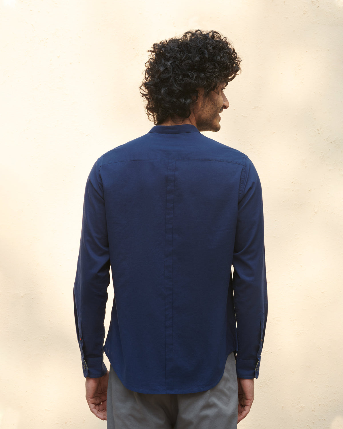 Back of a navy Nawab Shirt with a center seam and band collar.