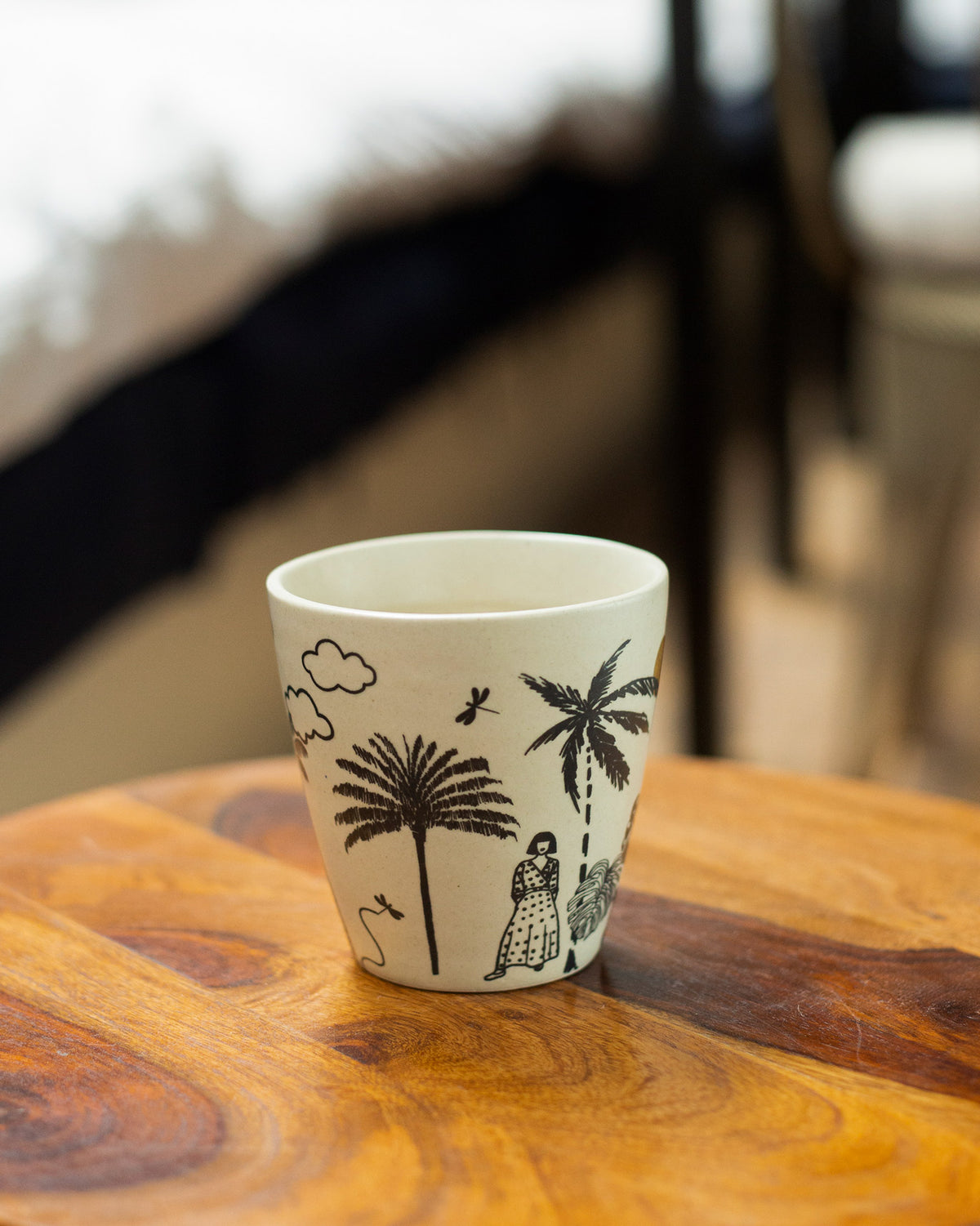 Ivory Mandovi Palm Mug with palm trees and clouds printed in black.