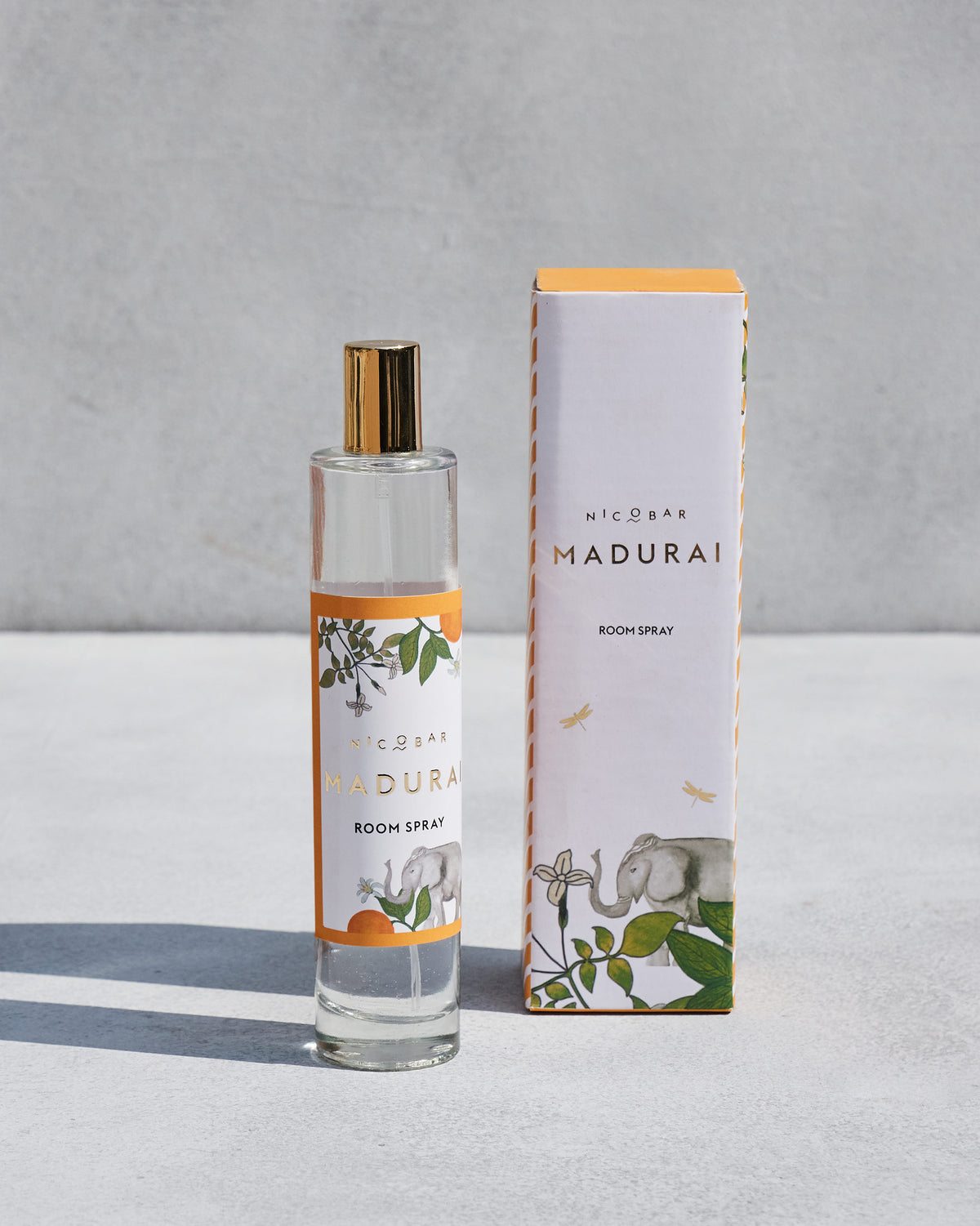 Madurai Room Spray bottle with an elephant and orange label, beside its box.