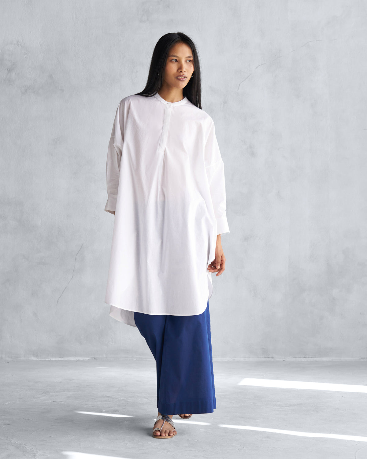 Side view of a white Lazy Sunday tunic with a high-low hem.