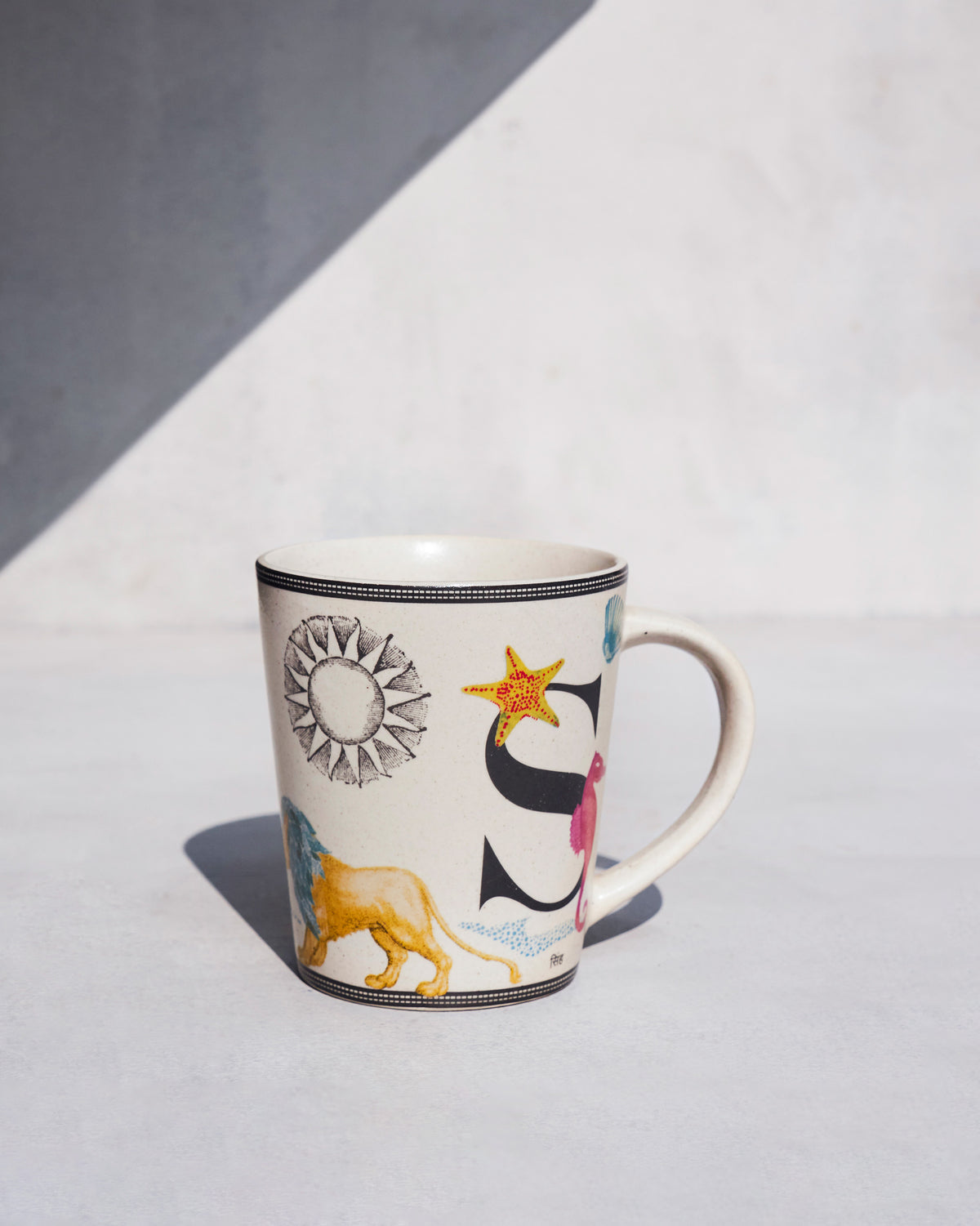 Singha mug with a lion motif and the letter S.