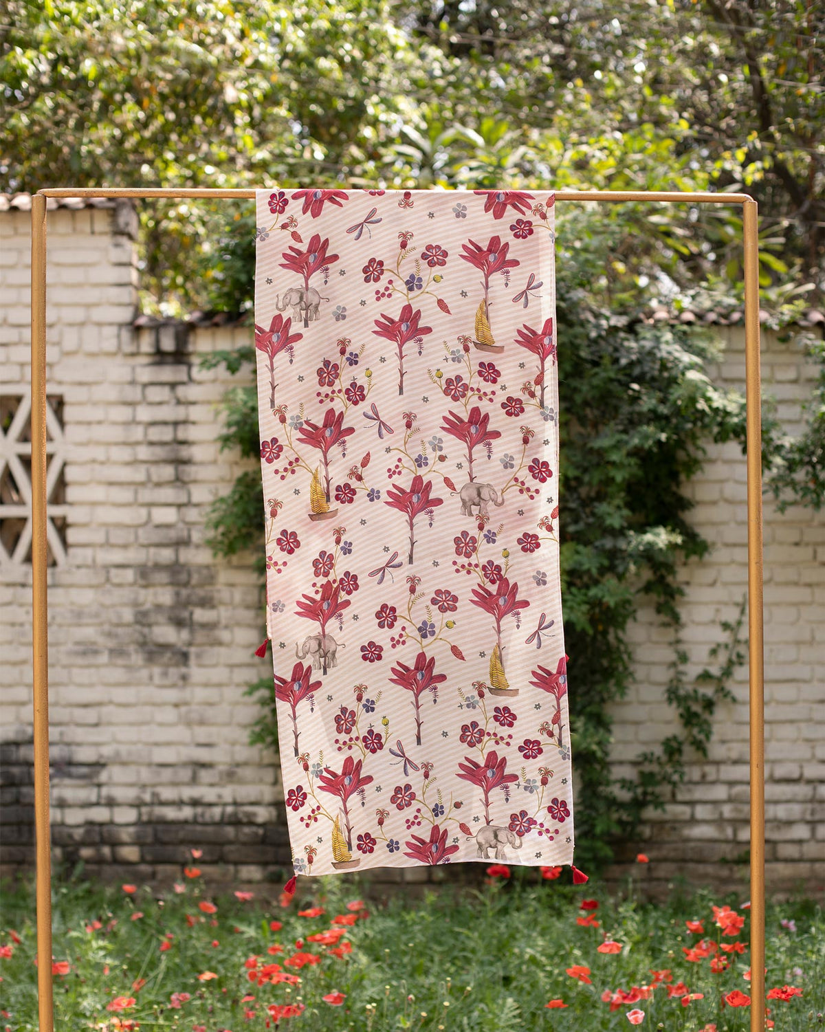 Cascade Scarf hung up to show its pink floral print and small elephants.