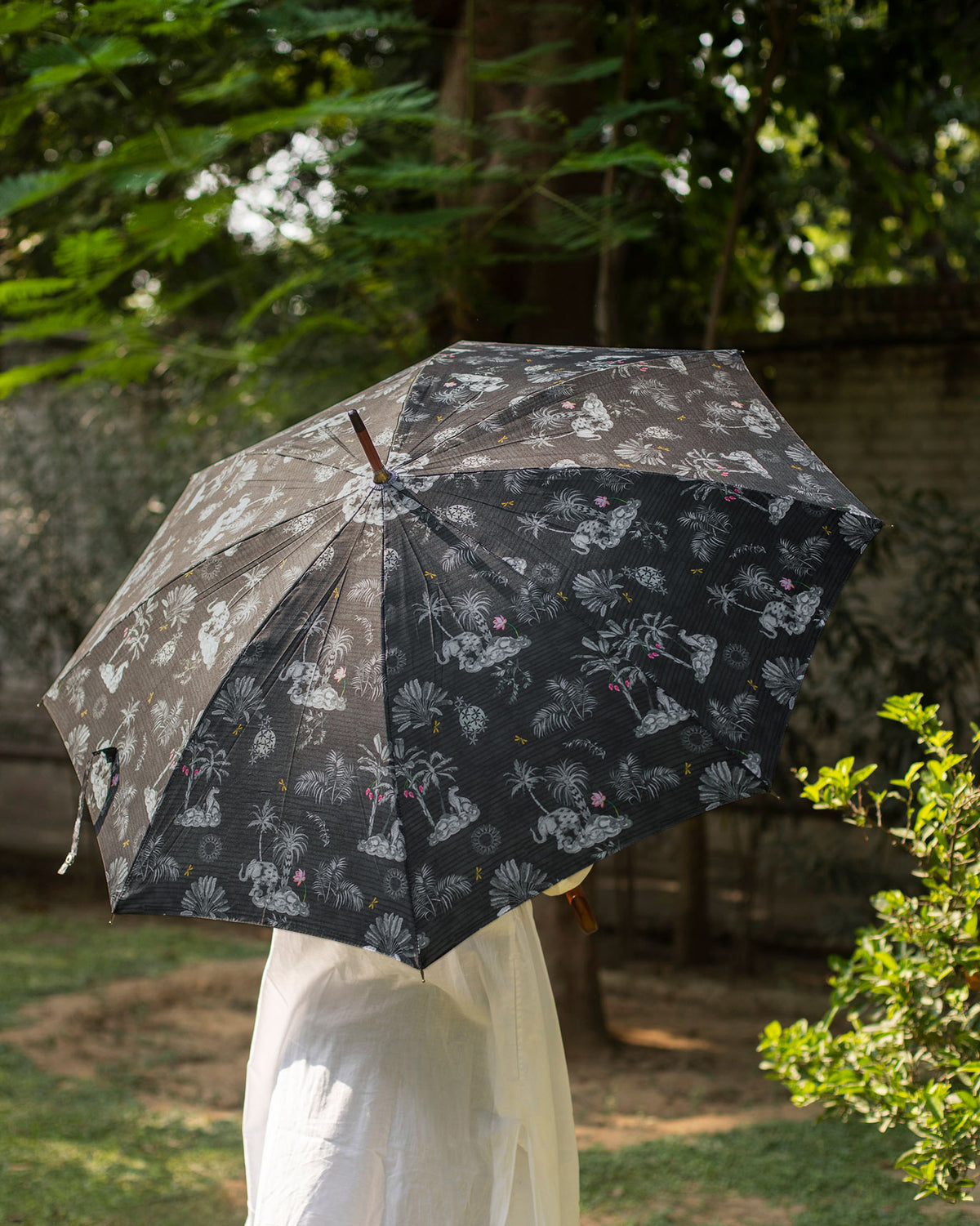 Periyar Umbrella open over a person, showing its palm and elephant print.