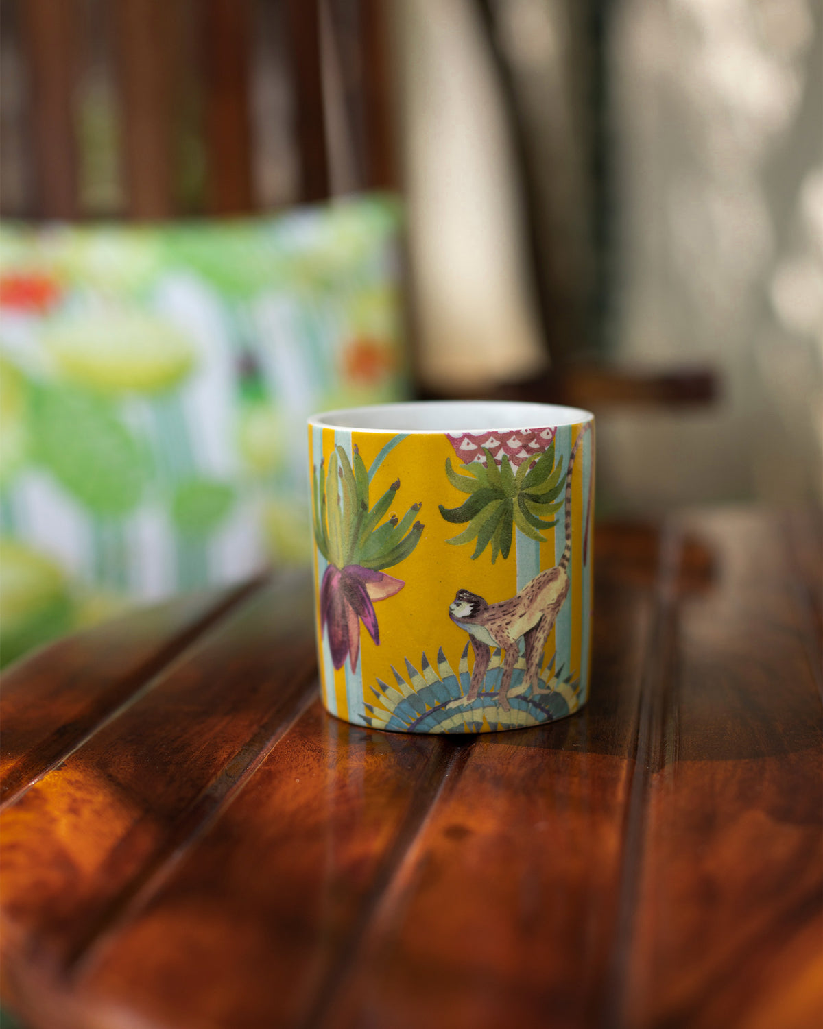 Close-up of a yellow Mahi Mug showing a purple flower and monkey motif.