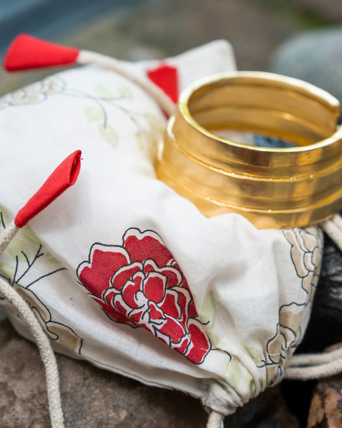 Gold Ridge bangle on a floral Nicobar gift pouch.