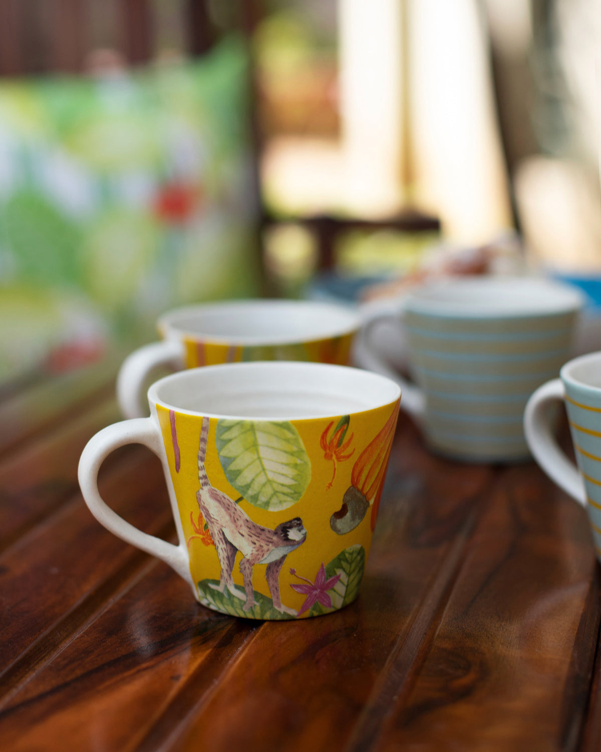 Yellow Mahi espresso mug with a monkey and cashew illustration.