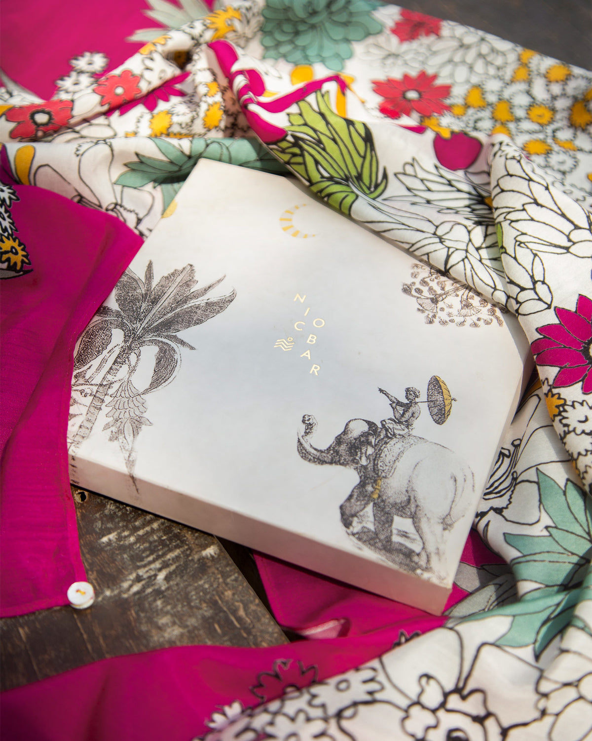 Nicobar gift box with an elephant and palm illustration beside the Cascade Scarf.