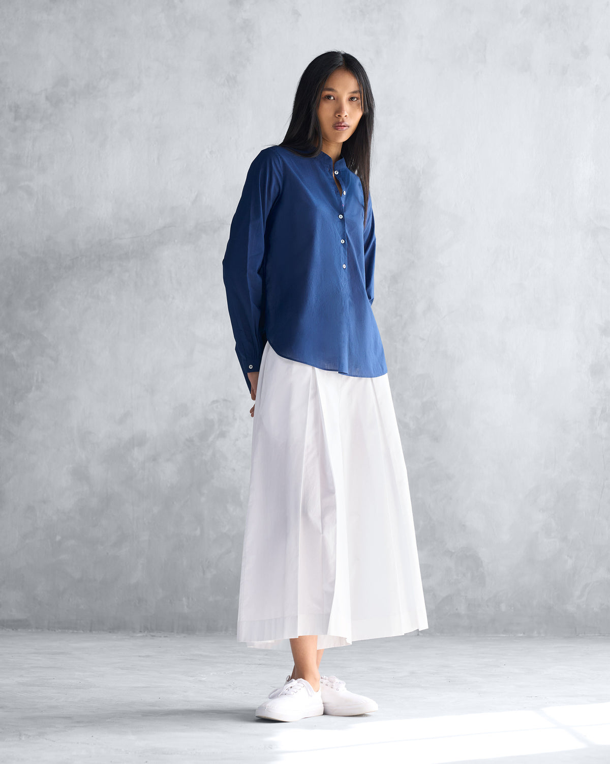 Full-length view of a navy mandarin collar top worn by a person.