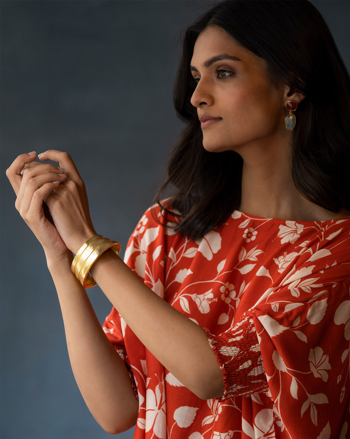 Person wearing gold Ridge bangles stacked on the wrist.