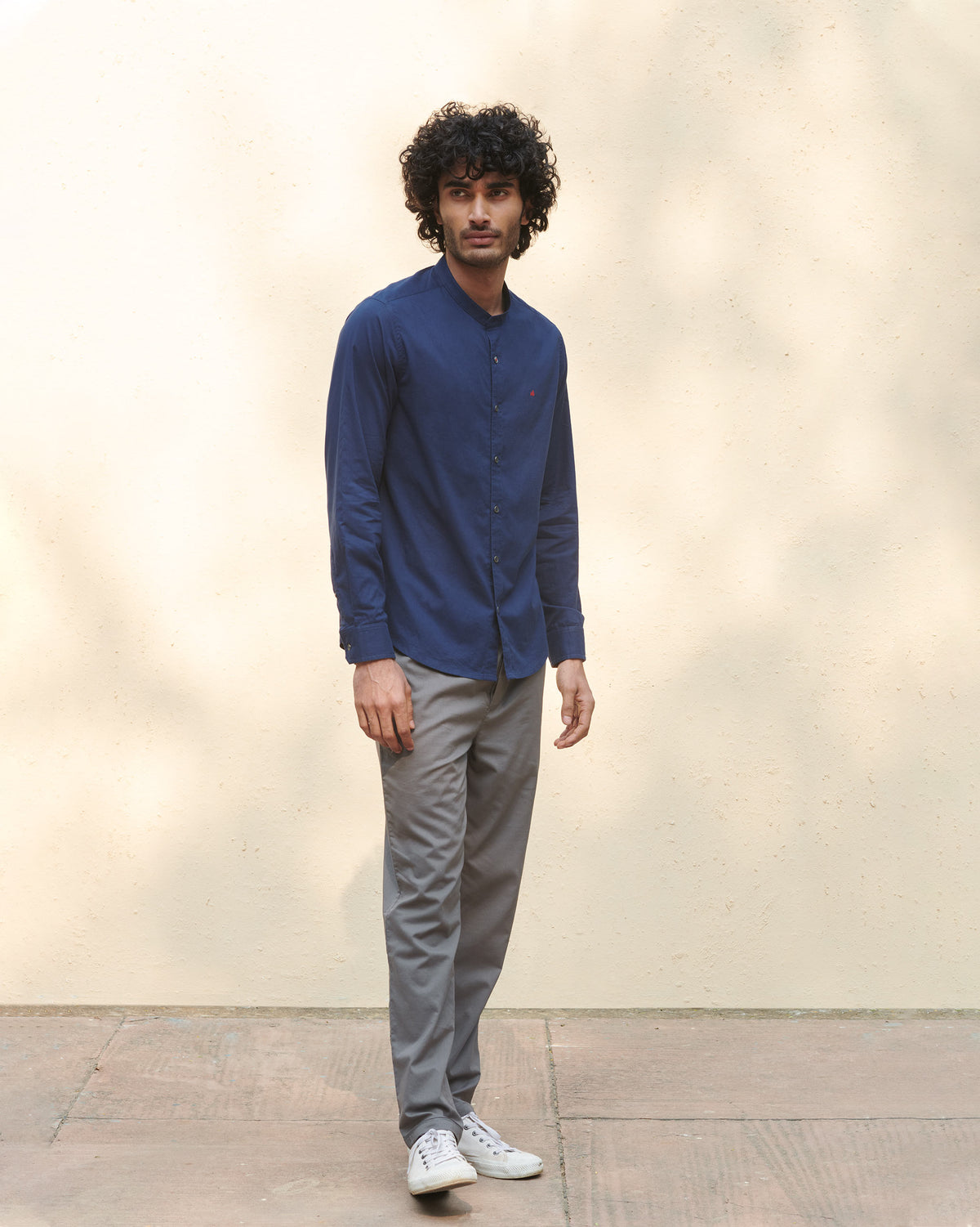 Person wearing a navy Nawab Shirt with a band collar, shown full length.