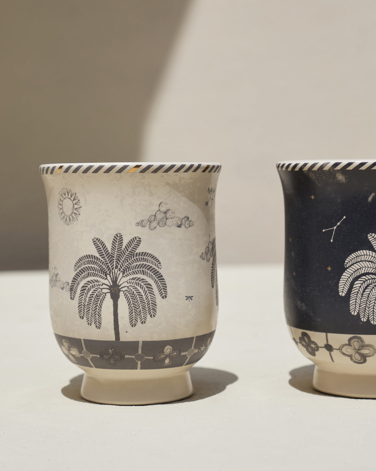 Close-up of the cream Twilight Tea Cup's palm tree and cloud motifs.