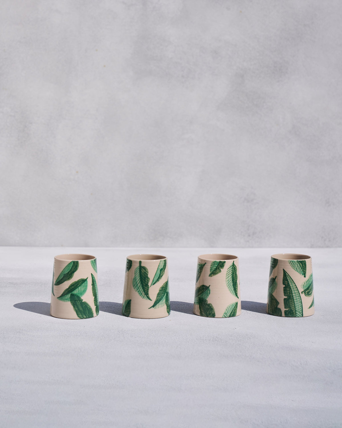 Four cream Galle kulhars with green banana leaf print.