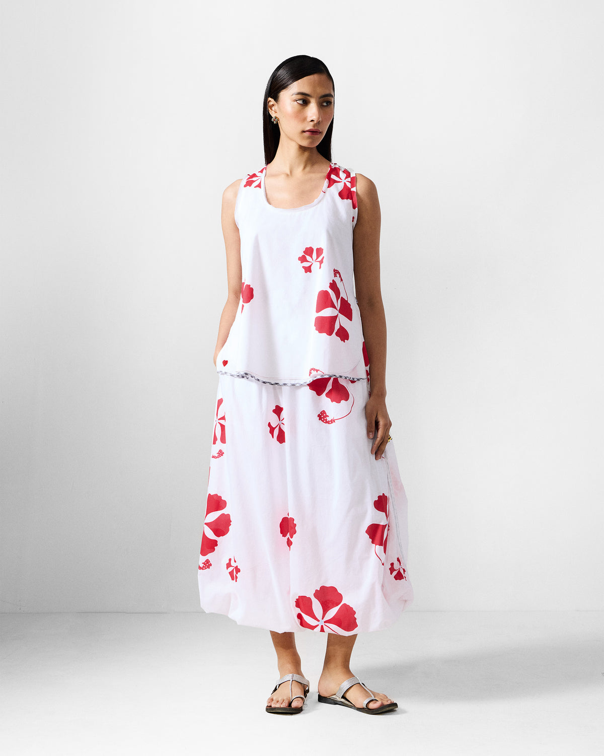 Person wearing the Kiva Set in white with a red floral print on the top and skirt.