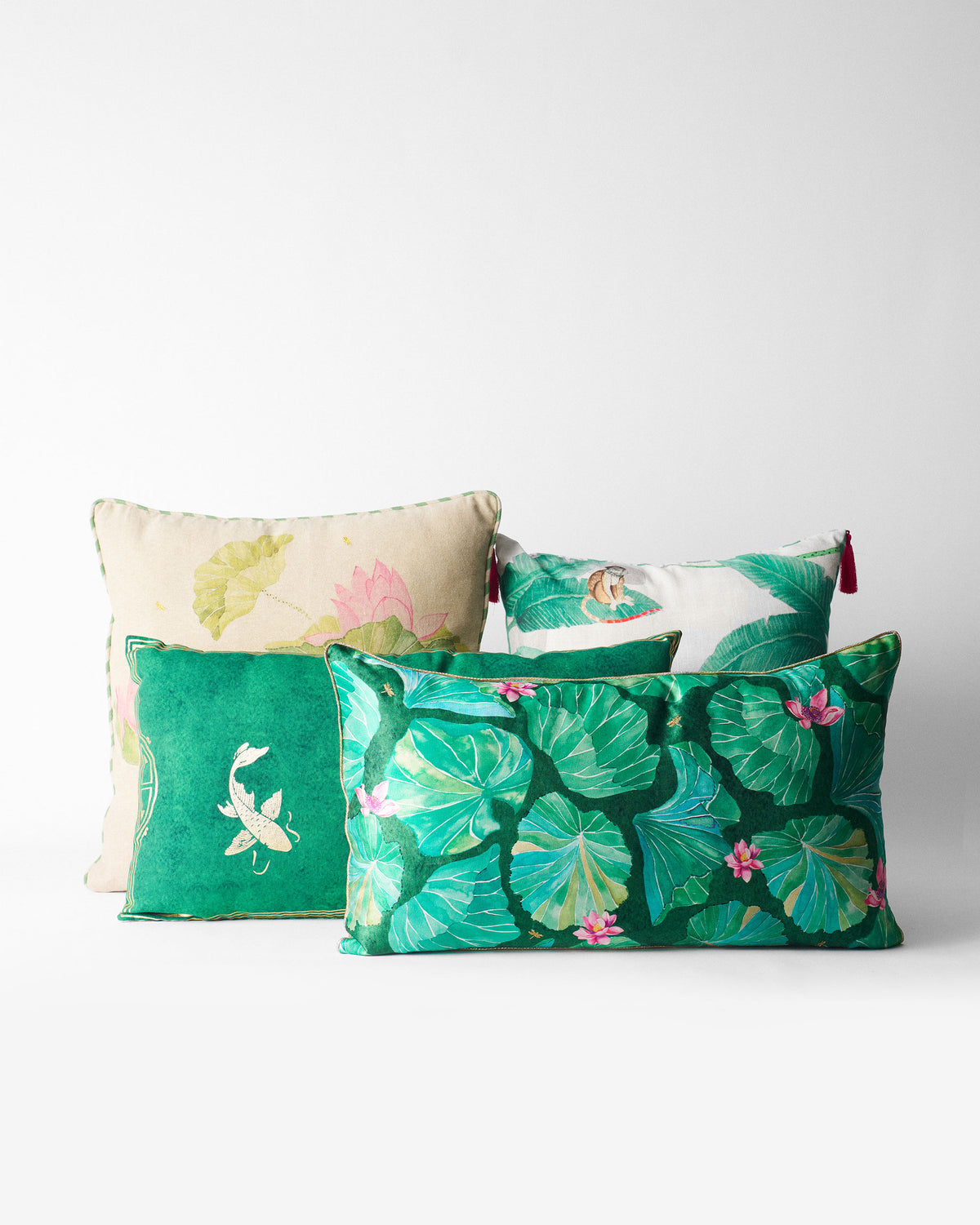 Lotus Garden cushion cover among other green and cream cushions, with the monkey print at top right.
