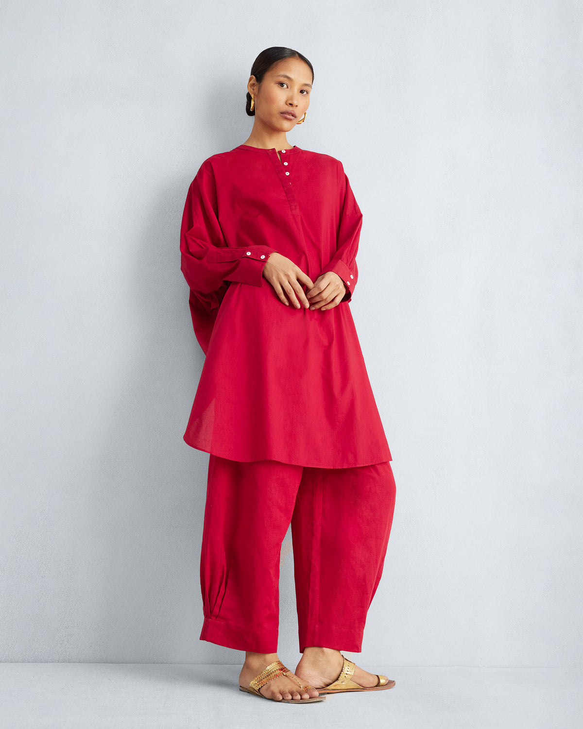 Person wearing a red Lazy Sunday tunic set with matching wide pants.
