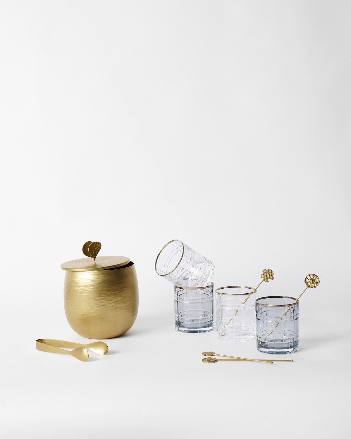 Celeste Bar Set with gold ice bucket, patterned whiskey glasses, and stirrers.