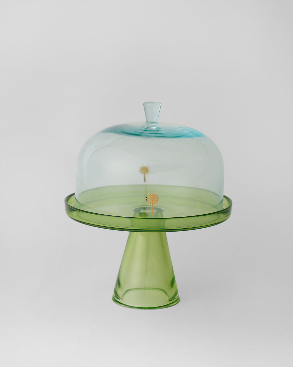 Vatika cake stand with a green glass pedestal and pale blue dome with a gold palm.