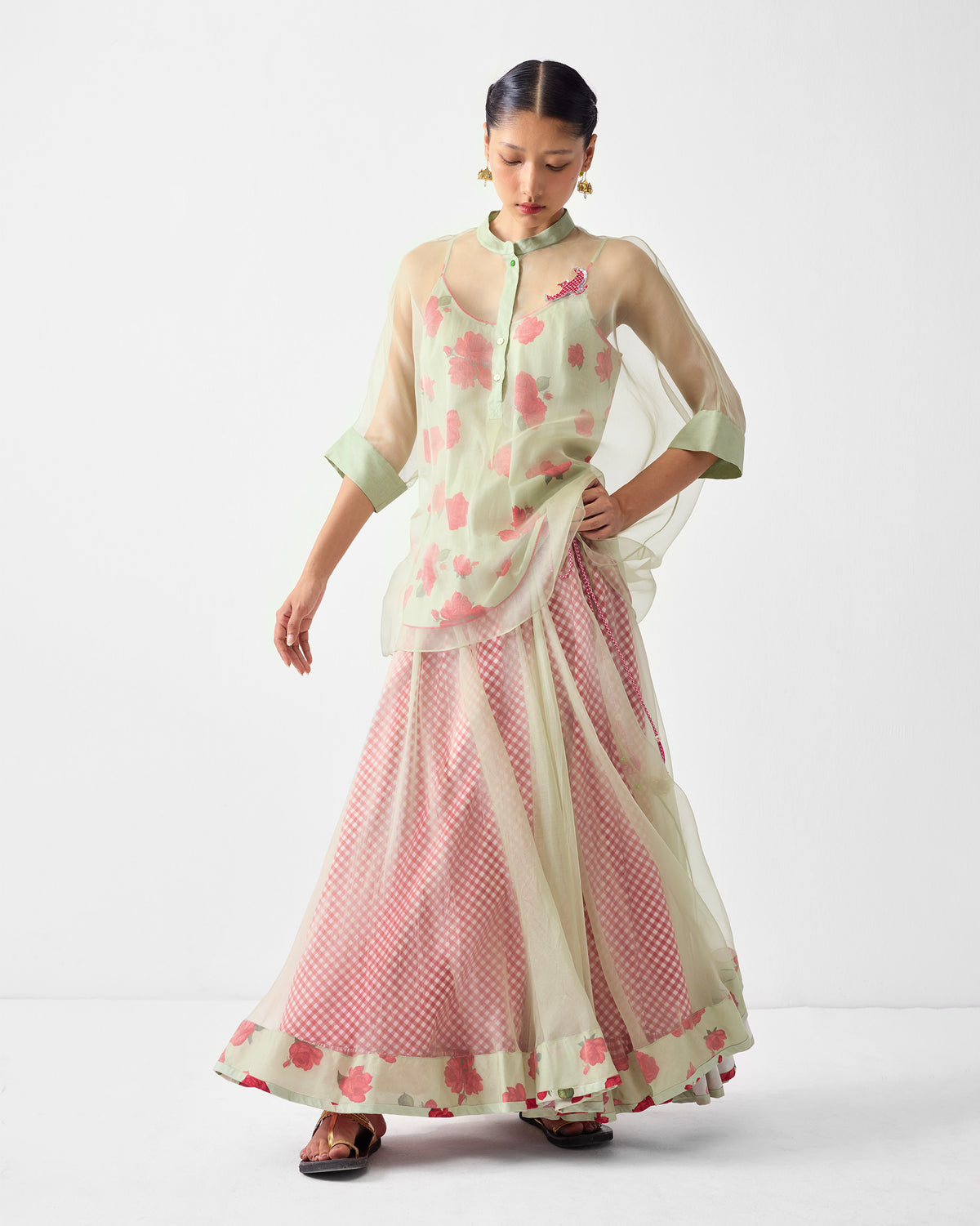Person wearing a Pushkar Skirt under a mint sheer top with pink florals.