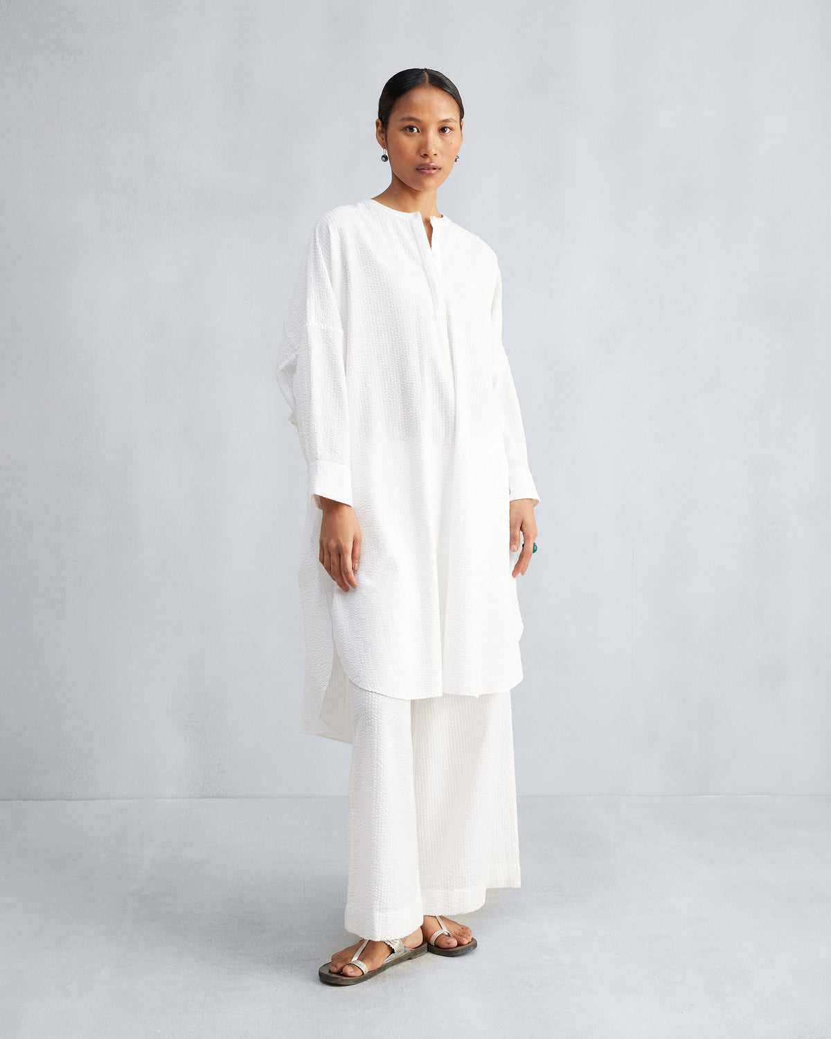 Person wearing a white Lazy Sunday tunic set with mandarin collar and wide pants.